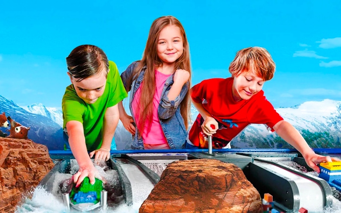 Children playing with LEGO boats at LEGOLAND Billund water ride.
