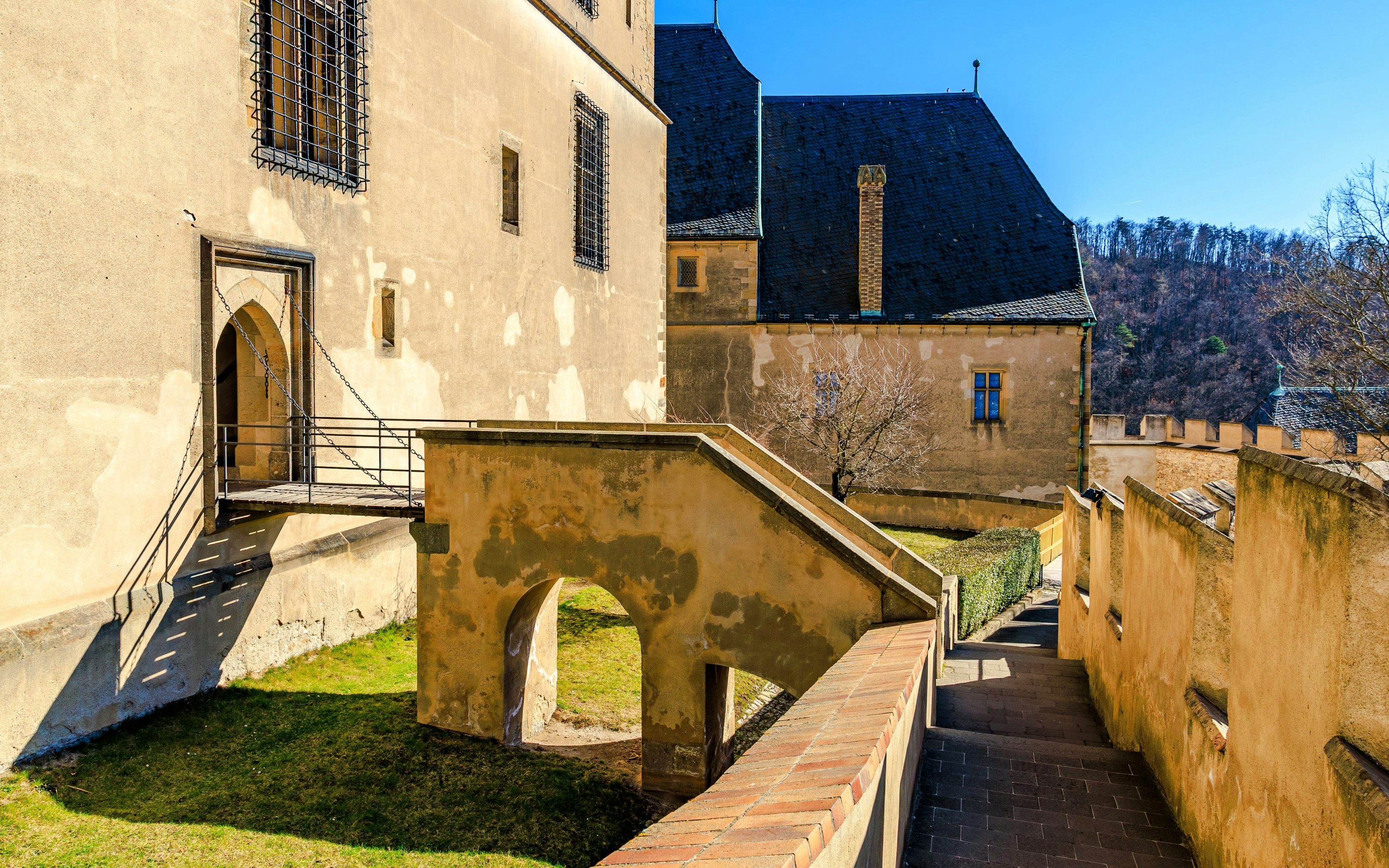 Courtyard view of Karlstejn Castle, Czech Republic, with stone walls and arched walkway.