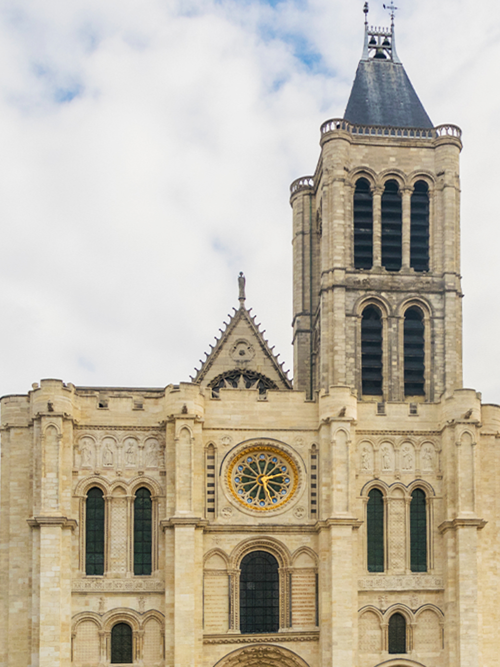 Basilica of Saint Denis facade with rose window and tower in Paris.