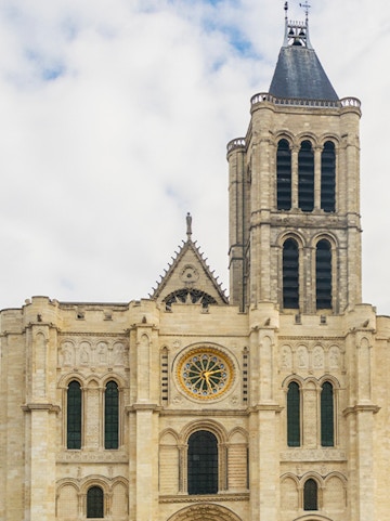 Basilica of Saint Denis facade with rose window and tower in Paris.