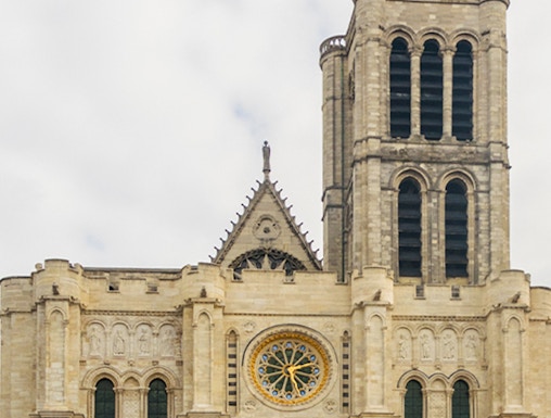 Basilica of Saint Denis facade with rose window and tower in Paris.