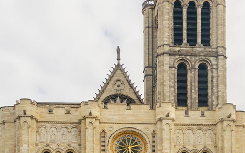 Basilica of Saint Denis facade with rose window and tower in Paris.