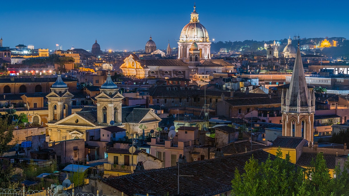 Panoramic view of Rome at sunset from Pincio Terrace, featuring the dome of Basilica of Ambrogio e Carlo al Corso.