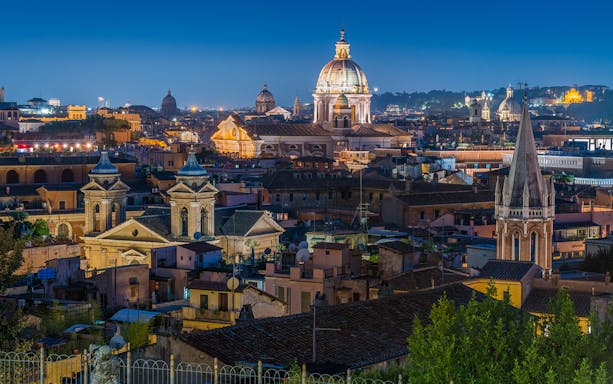 Panoramic view of Rome at sunset from Pincio Terrace, featuring the dome of Basilica of Ambrogio e Carlo al Corso.