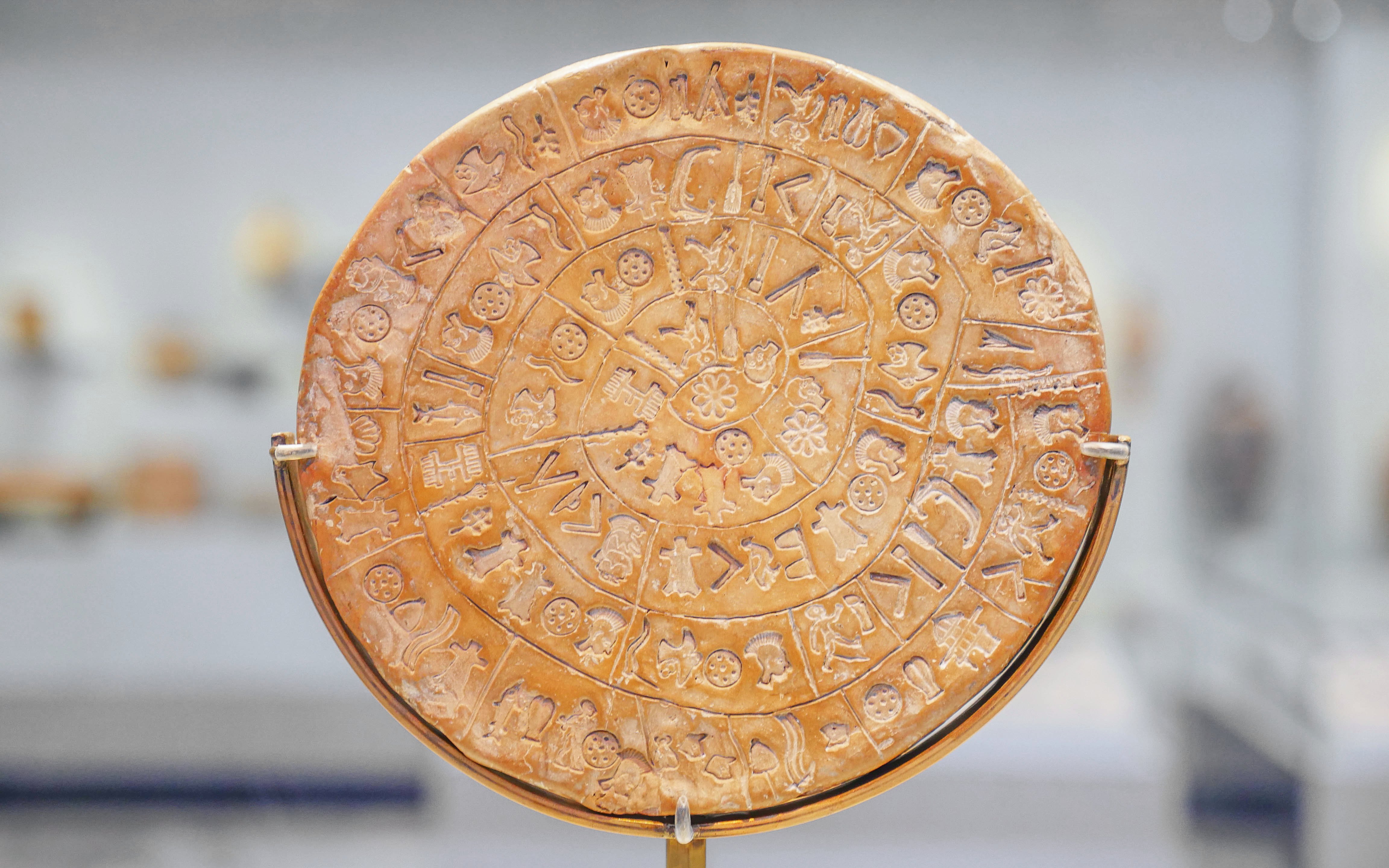 Phaistos Disk with ancient symbols in Archaeological Museum of Heraklion, Crete, Greece.