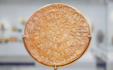Phaistos Disk with ancient symbols in Archaeological Museum of Heraklion, Crete, Greece.