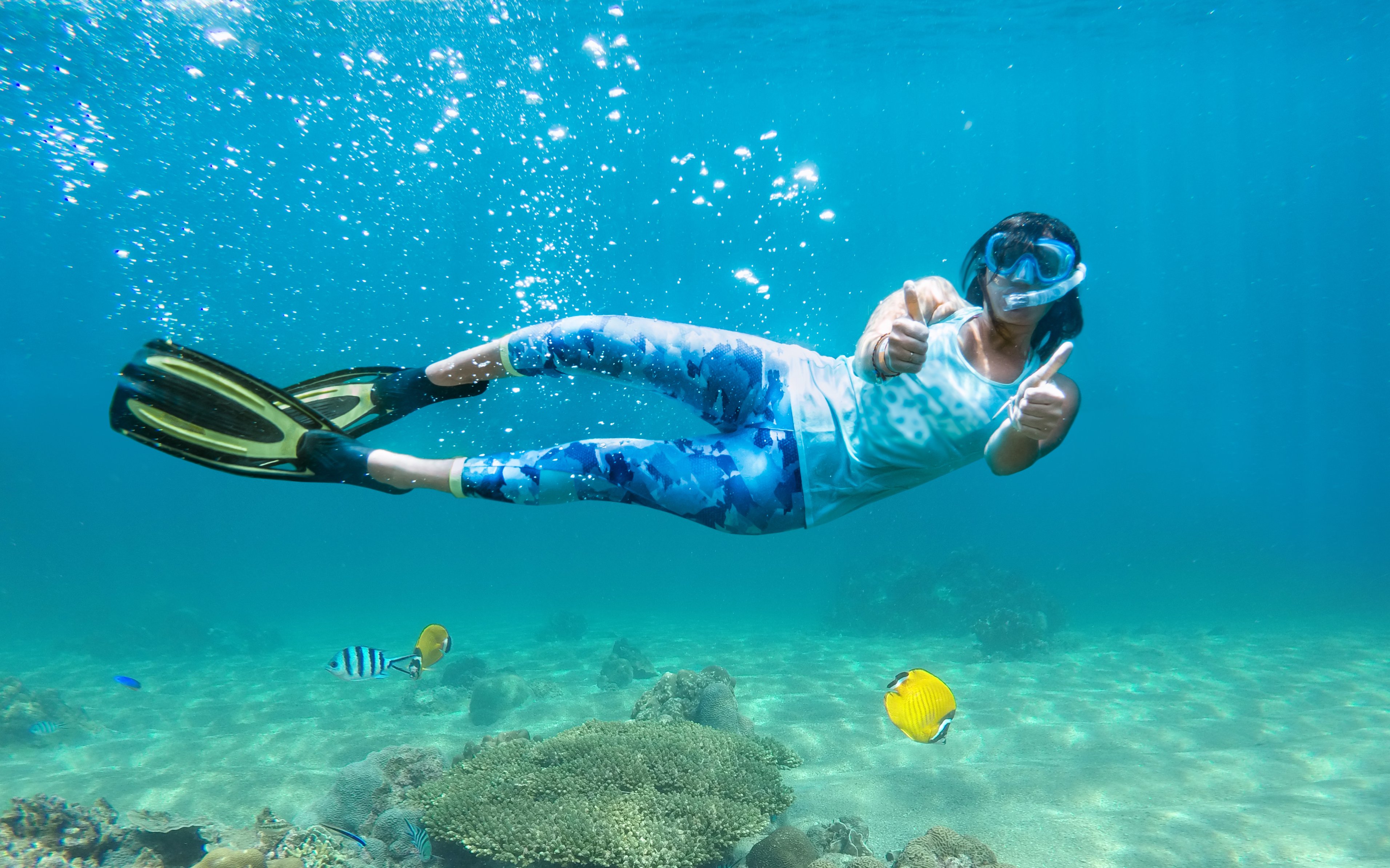 Snorkeler posing underwater with fish at Giftun Island, Hurghada.