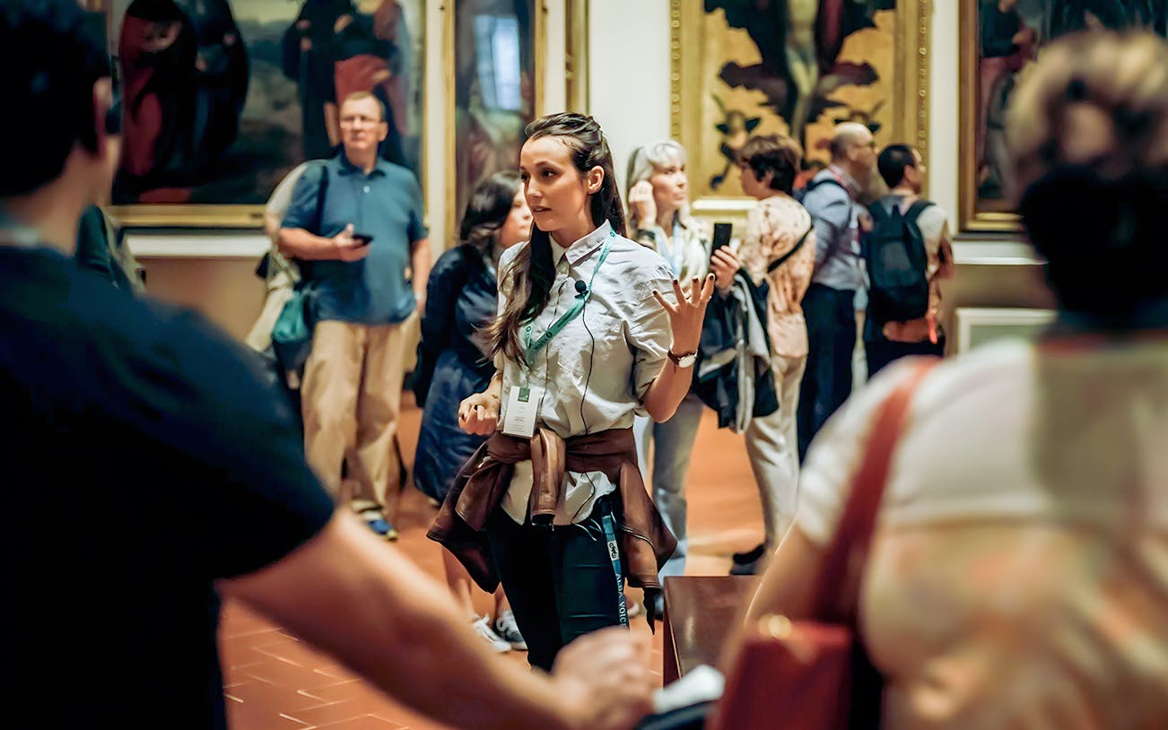 Tour guide explaining art to visitors at Musée d'Orsay, Paris to Giverny Impressionism day tour.
