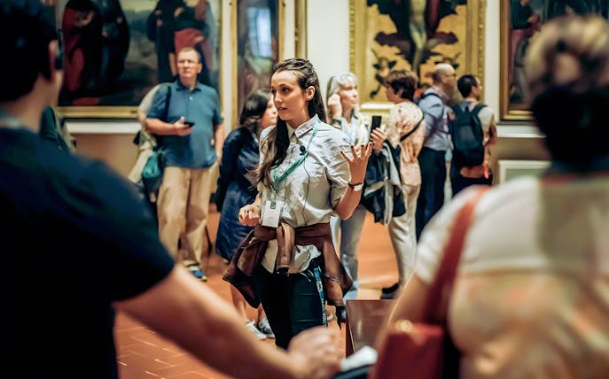 Tour guide explaining art to visitors at Musée d'Orsay, Paris to Giverny Impressionism day tour.