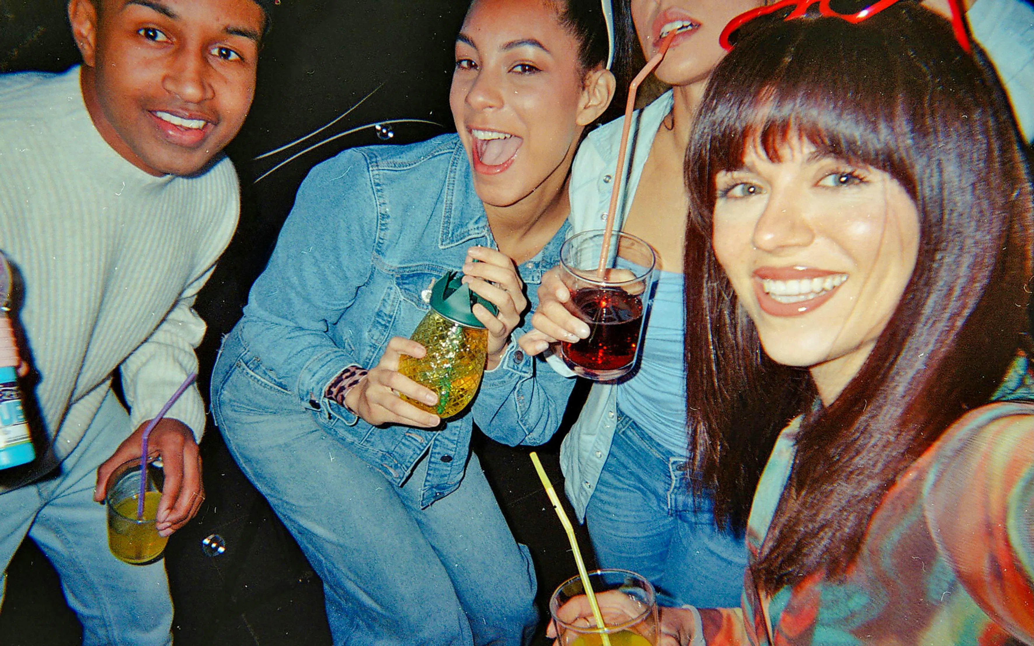 Friends enjoying drinks on a boat party at night.