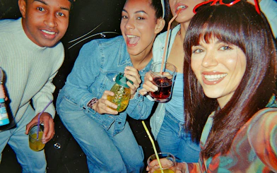 Friends enjoying drinks on a boat party at night.
