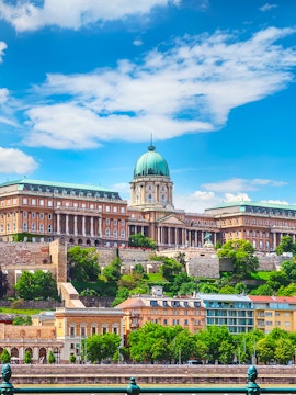 Buda Castle in Budapest with lush greenery and historic architecture.