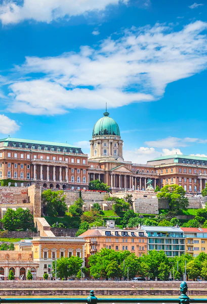 Buda Castle in Budapest with lush greenery and historic architecture.