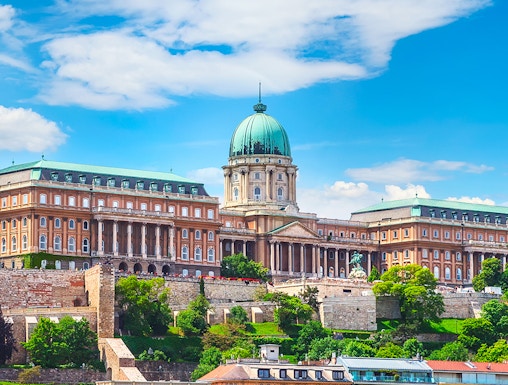 Buda Castle in Budapest with lush greenery and historic architecture.