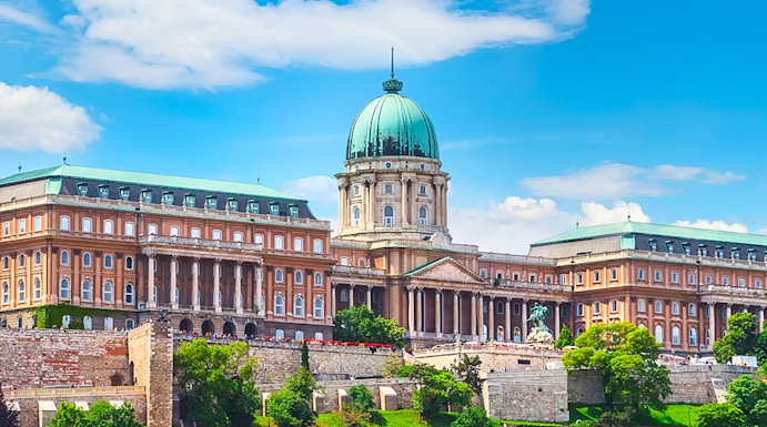 Buda Castle in Budapest with lush greenery and historic architecture.
