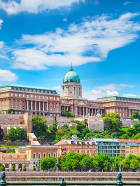 Buda Castle in Budapest with lush greenery and historic architecture.