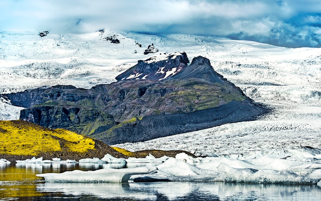 Fjallsarlon Glacier Lagoon with icebergs and snow-covered mountains in Iceland.
