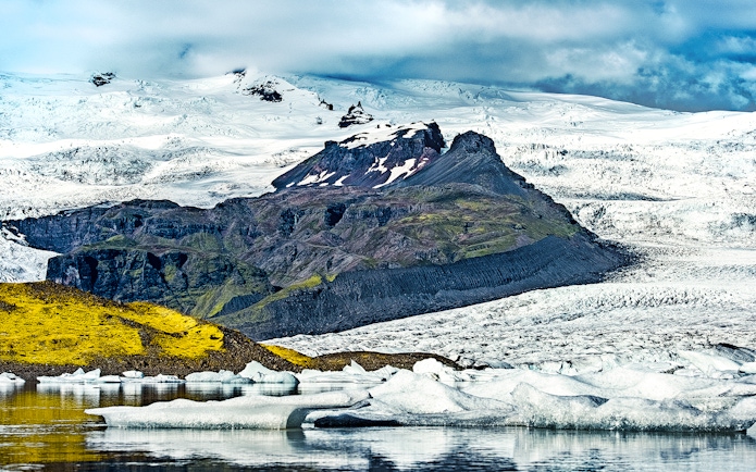 Fjallsarlon Glacier Lagoon with icebergs and snow-covered mountains in Iceland.