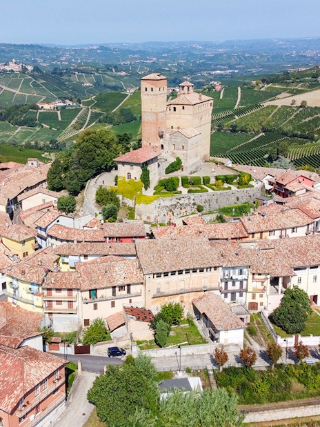 Aerial view of a historic castle and village in the vineyards of Piemonte, Italy.