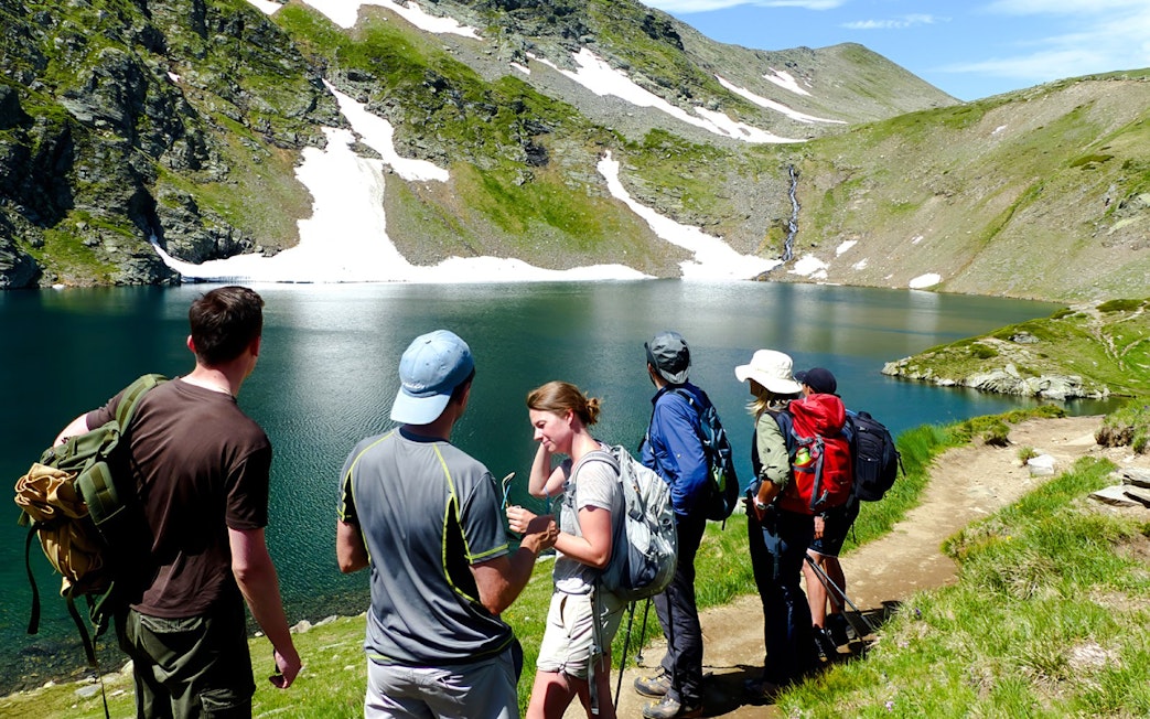 Hikers enjoying the view of a lake and mountains during The Seven Rila Lakes tour from Sofia.