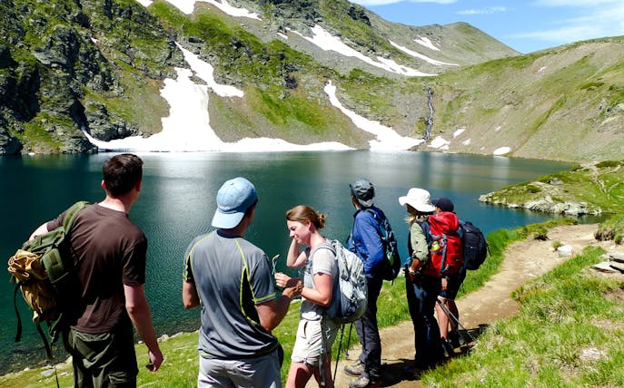 Hikers enjoying the view of a lake and mountains during The Seven Rila Lakes tour from Sofia.