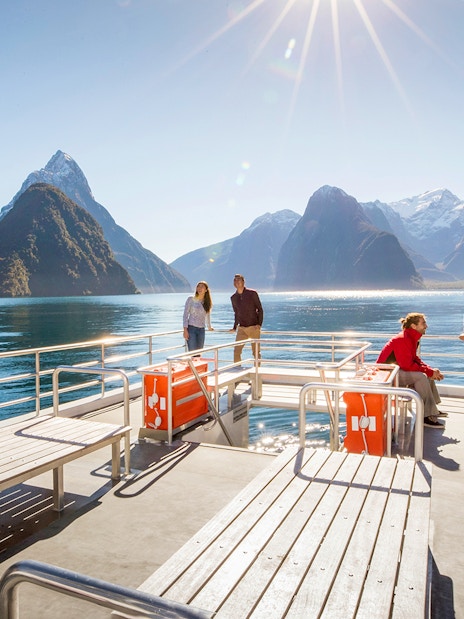 Cruise passengers enjoying views of Milford Sound's mountains and water in New Zealand.