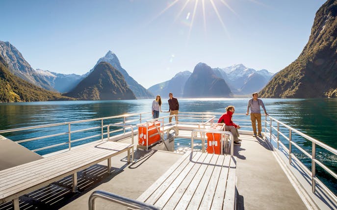 Cruise passengers enjoying views of Milford Sound's mountains and water in New Zealand.