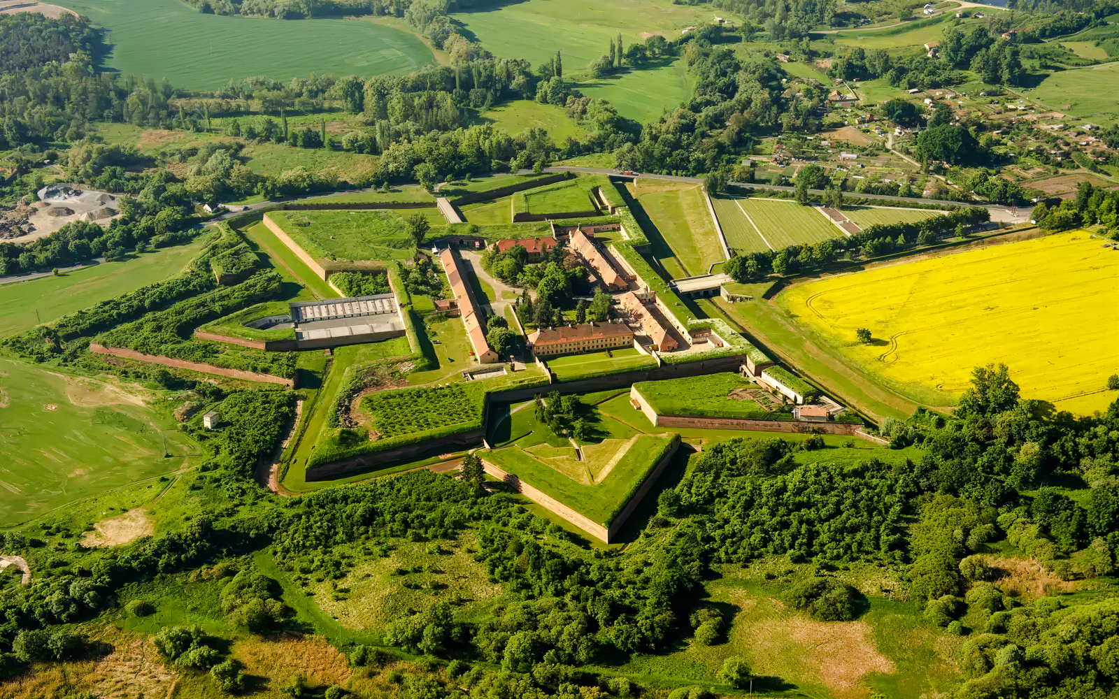 Aerial view of Terezín Concentration Camp surrounded by green fields near Prague.
