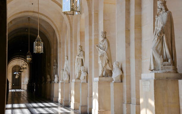 Statues lining a corridor at Versailles Palace, France.