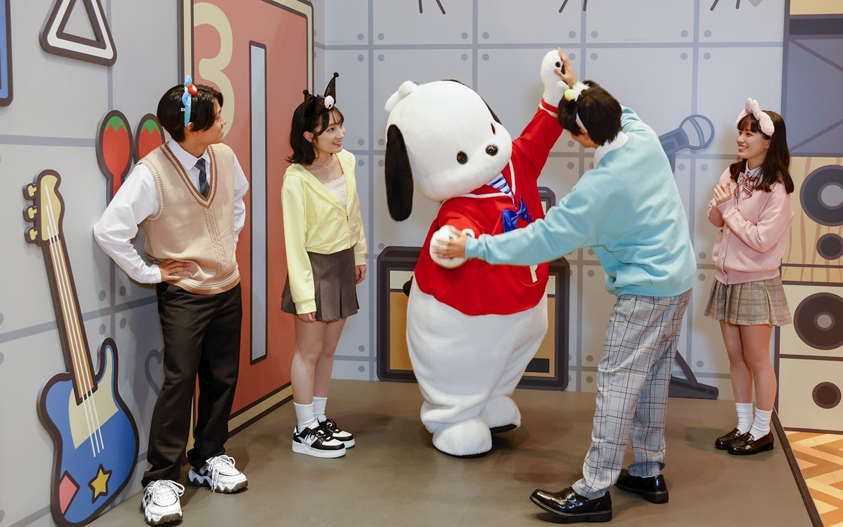 Visitors interacting with a character at Sanrio Puroland.