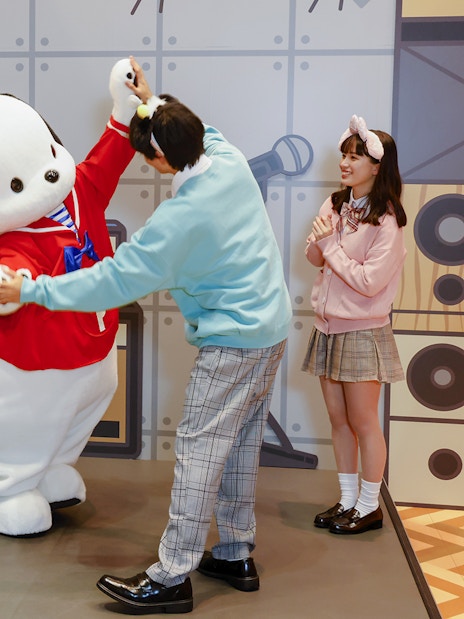 Visitors interacting with a character at Sanrio Puroland.