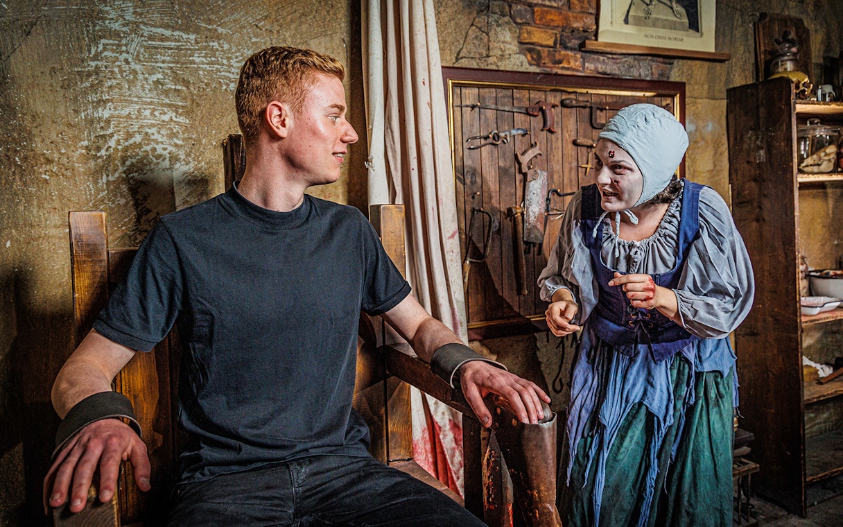 Visitor interacting with actor in historical costume at Berlin Dungeon.