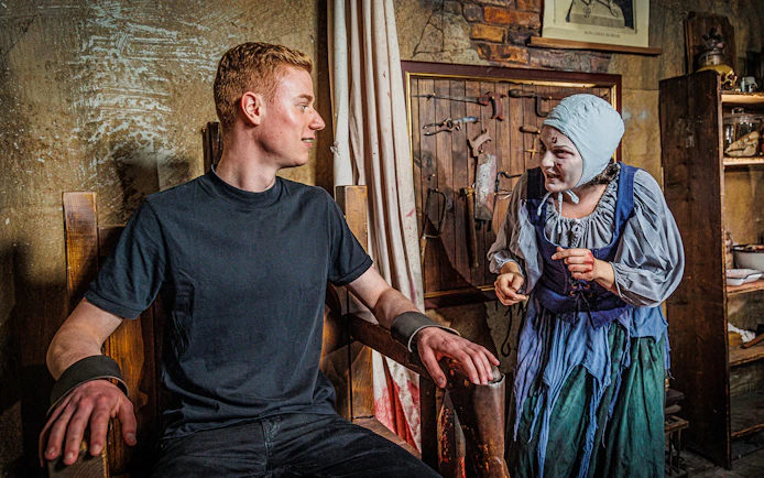 Visitor interacting with actor in historical costume at Berlin Dungeon.