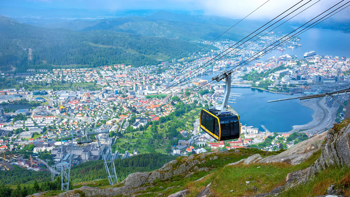 Bergen cityscape and harbor viewed from Ulriken Mountain with cable car in foreground.