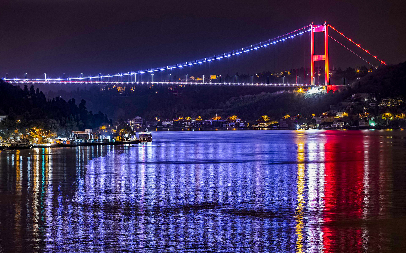 Bosphorus Bridge illuminated at night over the Bosphorus Strait, Istanbul.