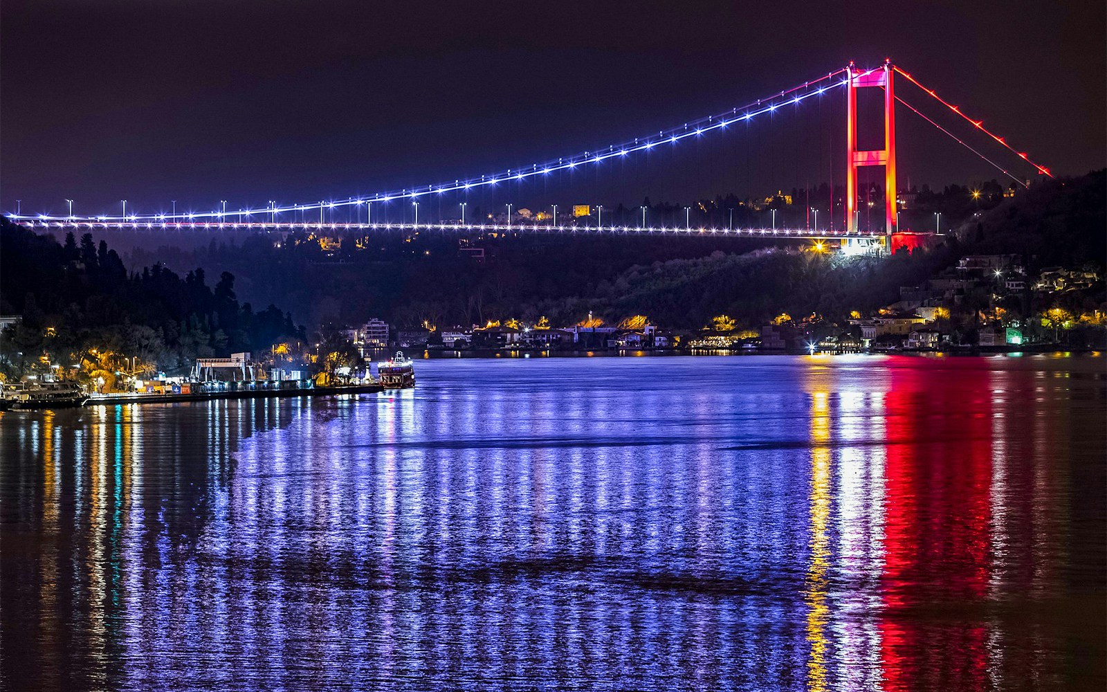 Bosphorus Bridge illuminated at night over the Bosphorus Strait, Istanbul.