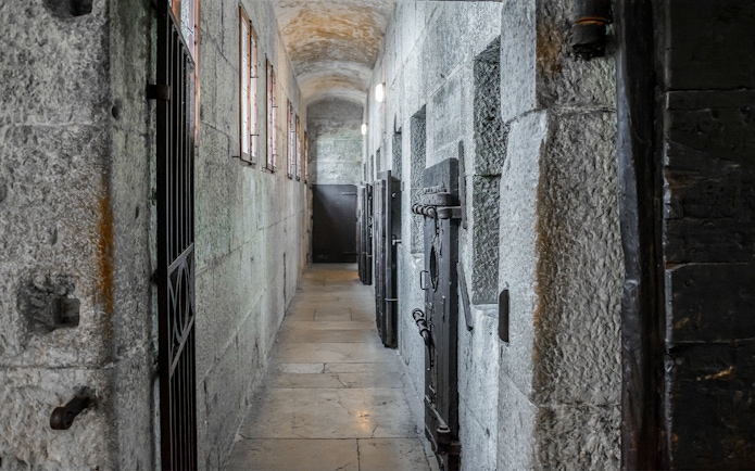 Doge's Palace Piombi Prison corridor with stone walls and iron doors, Venice, Italy.