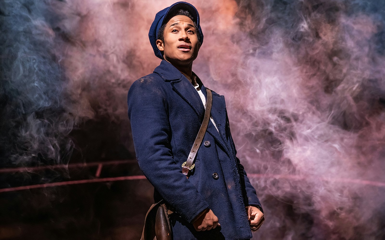 Performer in a blue coat on stage with smoke, related to Sweeney Todd.