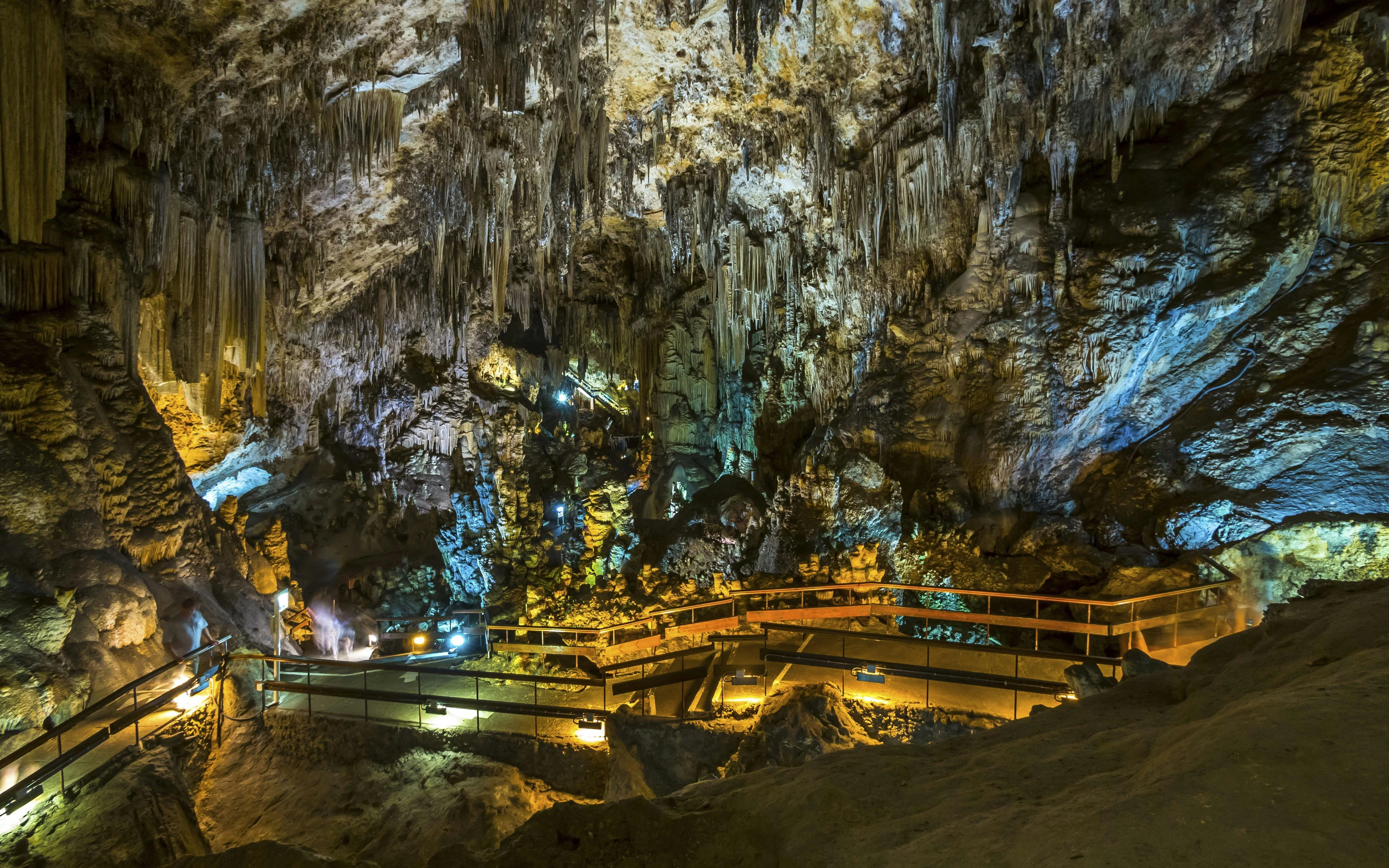 Walkway through illuminated stalactites in the Caves of Nerja, Spain.