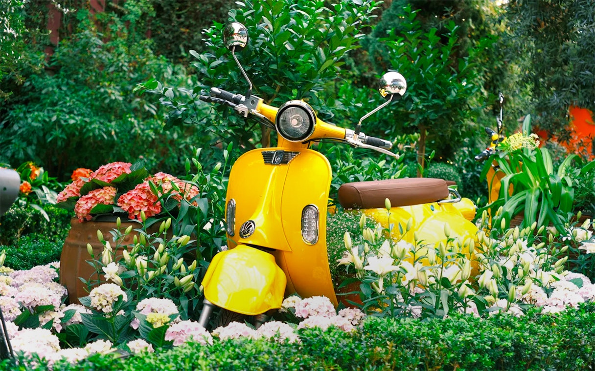 Yellow scooter surrounded by lilies and hydrangeas at Gardens by the Bay 2025 Lilytopia.