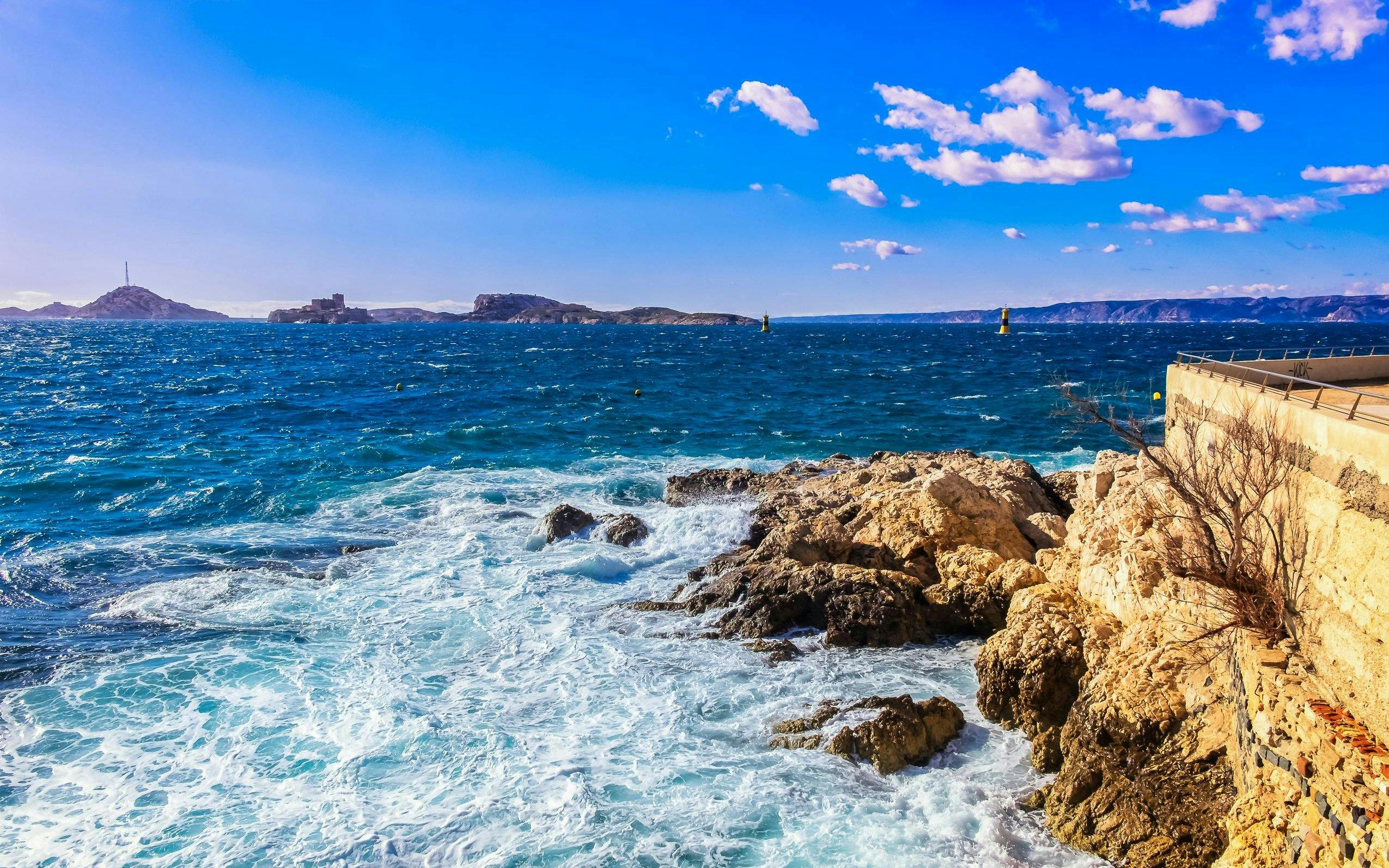 Frioul Archipelago view with Châteaux d’If in the distance, rocky coastline in Marseille.