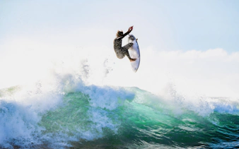Tourist surfing a wave in Lisbon, Portugal.