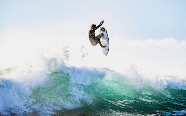 Tourist surfing a wave in Lisbon, Portugal.