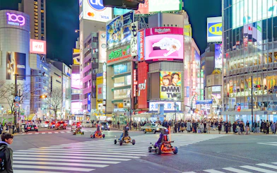 Go-karting at night in Shibuya, Tokyo, with illuminated cityscape and bustling streets.