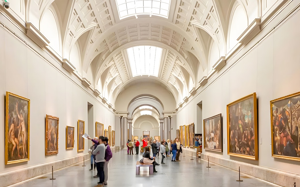 Visitors viewing paintings in a gallery at Prado Museum, Madrid.
