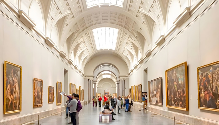 Visitors exploring artwork inside Prado Museum, Madrid, during a guided tour with skip-the-line entry.
