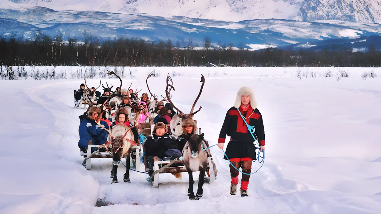 Reindeer sledding with Sami guide in snowy landscape, showcasing Sami culture.
