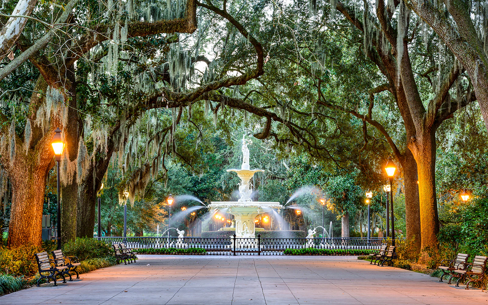 Forsyth Park fountain surrounded by oak trees and benches in Savannah, Georgia.