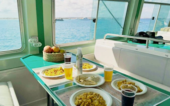 Lunch setup on Ibiza to Formentera cruise with paella and drinks by the sea.