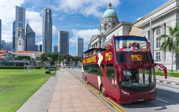 Singapore Hop-On-Hop-Off bus near National Gallery with city skyline.